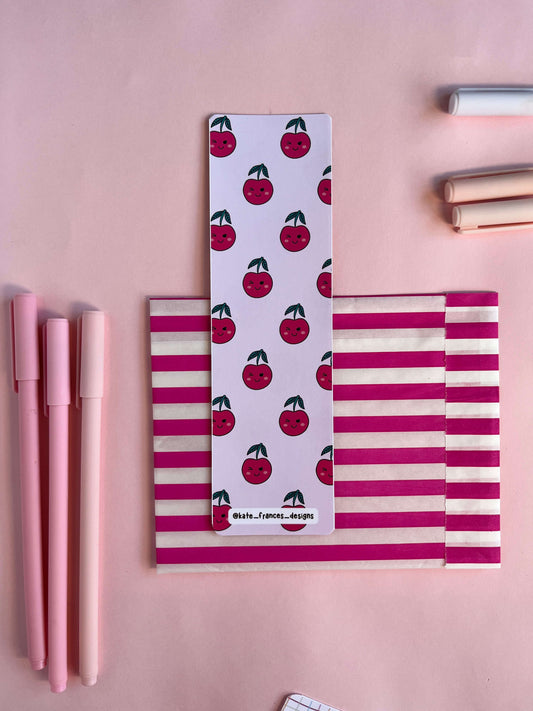 Kawaii cherry bookmark on a pink background