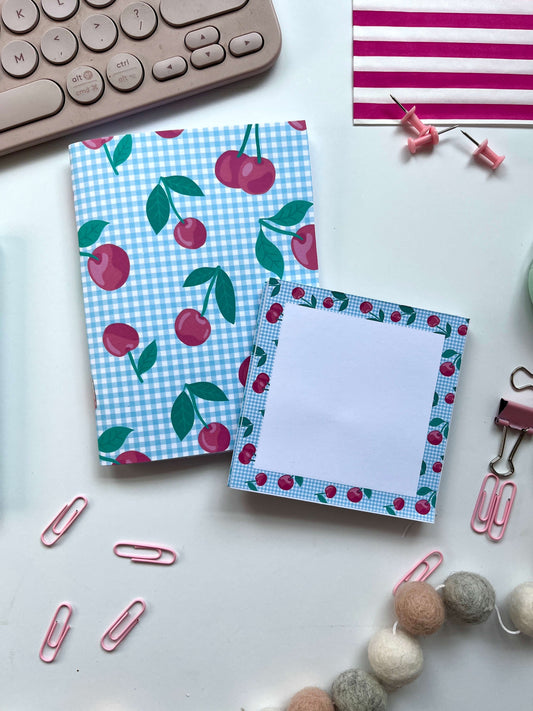 A5 Notebook and matching memo block with cherry design on a desk with office supplies